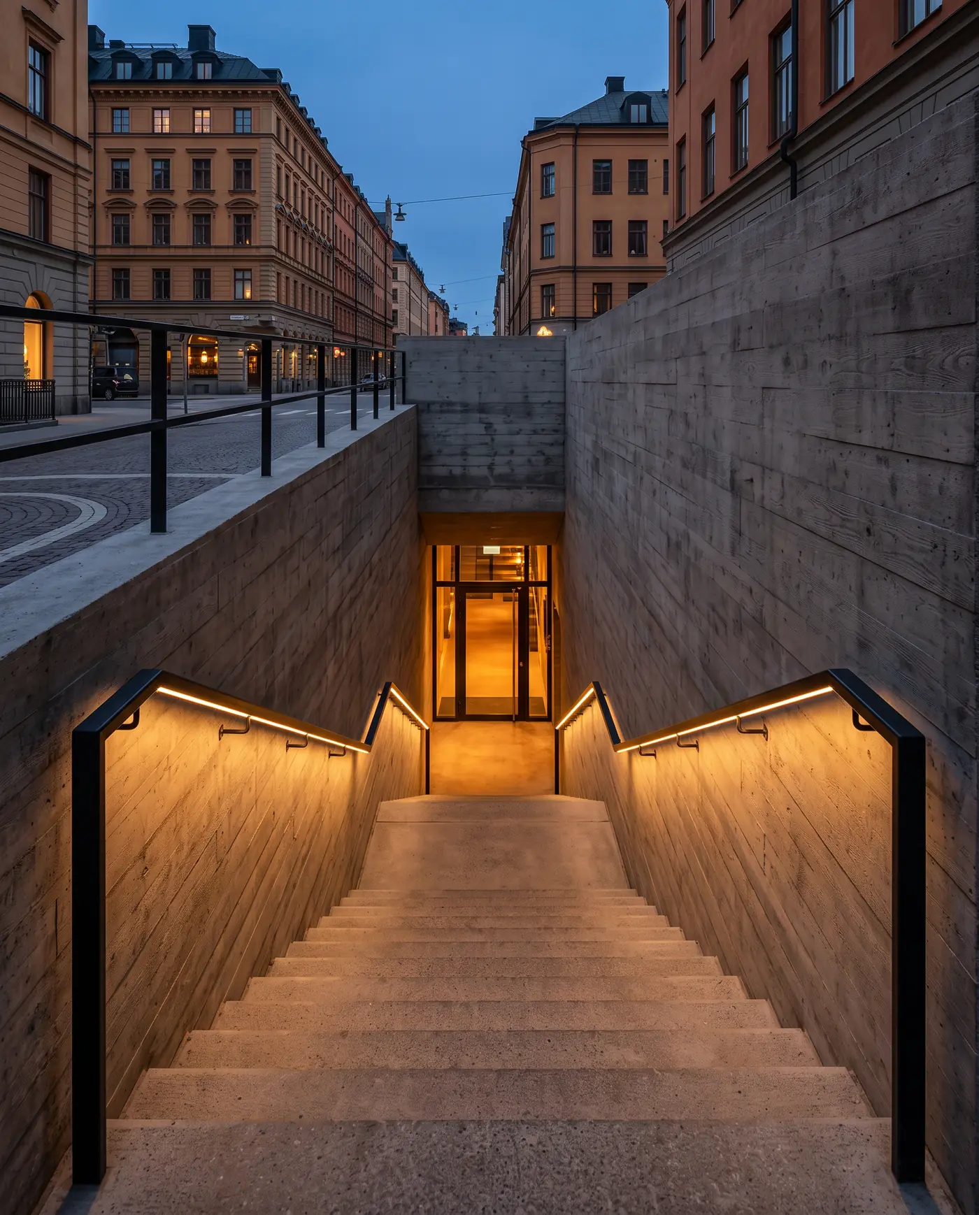 Konceptbild av en betongtrappa från gatan ned till en upplyst entré i källarplan.